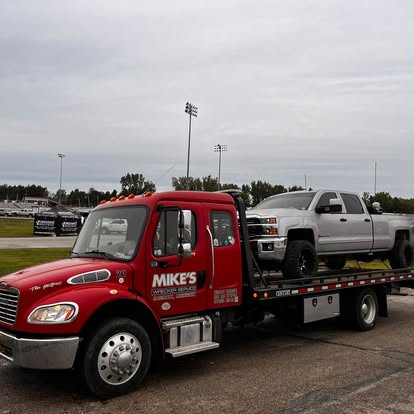 Mike's Wrecker flatbed carrying a pickup truck