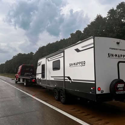 Travel trailer being towed by Mike's Wrecker on the highway
