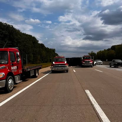 Mike's Wrecker flatbeds working a highway shoulder