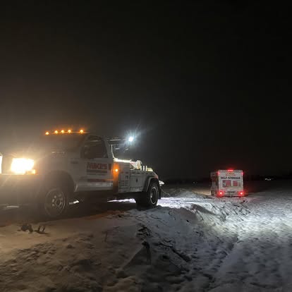 Mike's Wrecker recovering a vehicle in deep snow at night