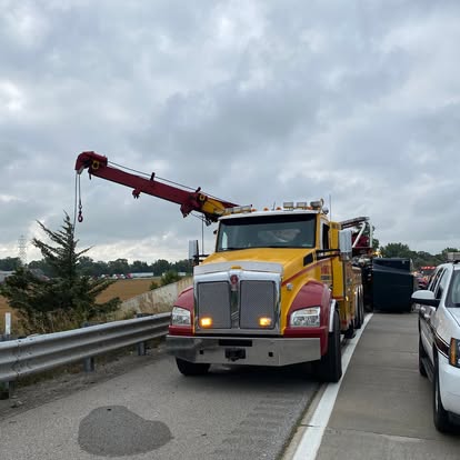 Mike's heavy wrecker with the boom raised on the highway shoulder