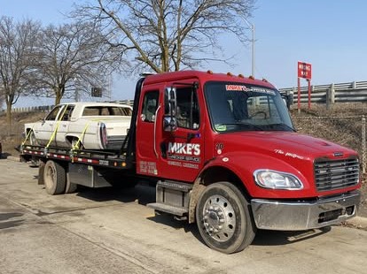 Mike's Wrecker flatbed carrying a car