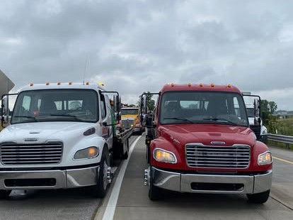 Two Mike's Wrecker trucks on a highway shoulder